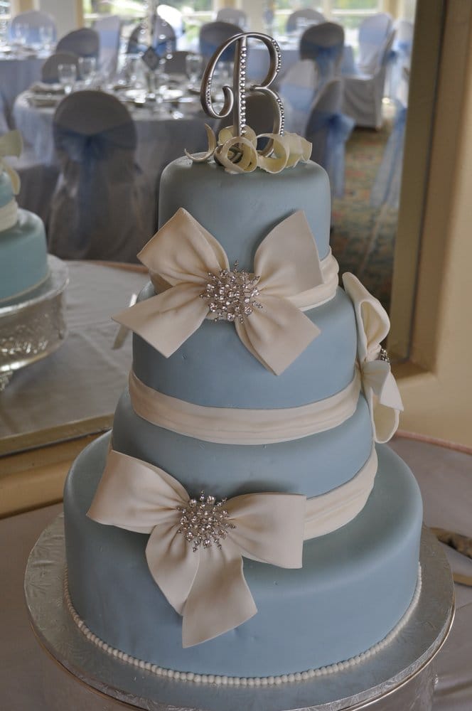 Blue fondant and crisp white gumpaste bows adorned with stone brooches