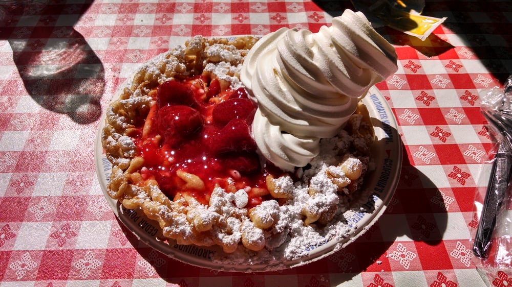 Fully loaded funnel cake with strawberries and ice cream